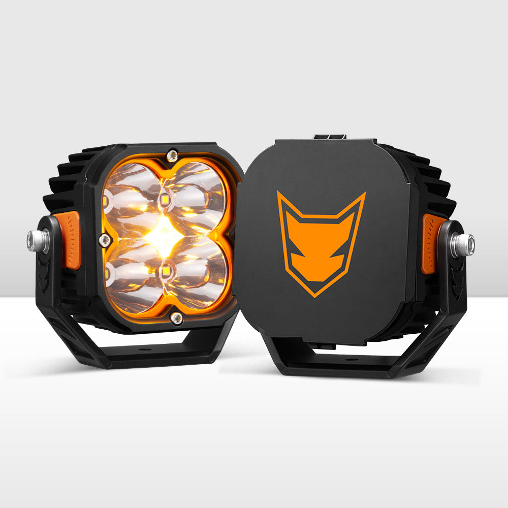 Two black and orange LED vehicle pod lights with a Lightfox logo on a white background Two black and orange LED vehicle pod lights with a Lightfox logo on a white background