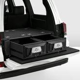 Black storage drawers in the back of a white Toyota Land Cruiser SUV on a white background