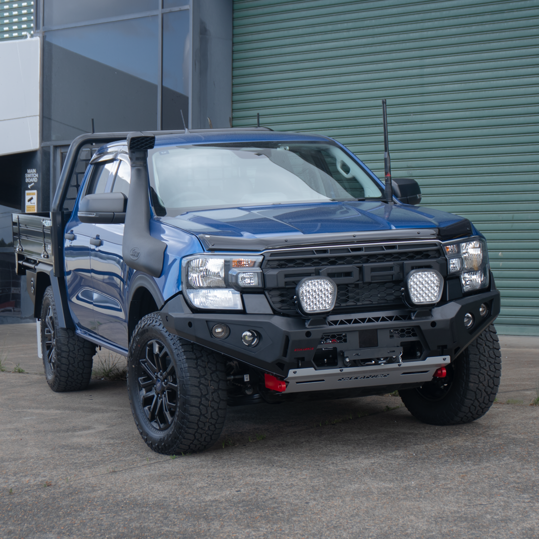 Blue Ford Ranger bakkie pickup truck with off-road modifications and Rockarmor bumper bull bar parked outside.