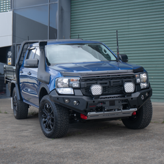 Blue Ford Ranger bakkie pickup truck with off-road modifications and Rockarmor bumper bull bar parked outside.
