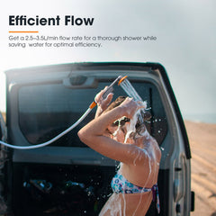 Person washing next to a car with a portable camping hose, surrounded by desert landscape.
