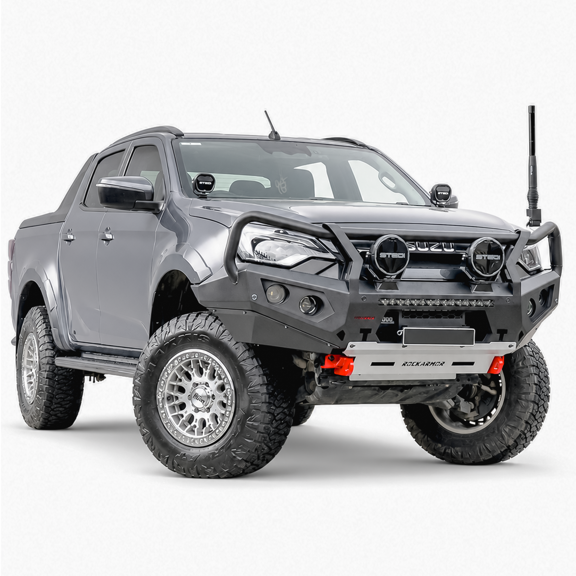 A dark gray lifted Isuzu bakkie with a heavy-duty black front bumper bull bar, dual round roof lights, and off-road tires, photographed on a seamless white studio background.