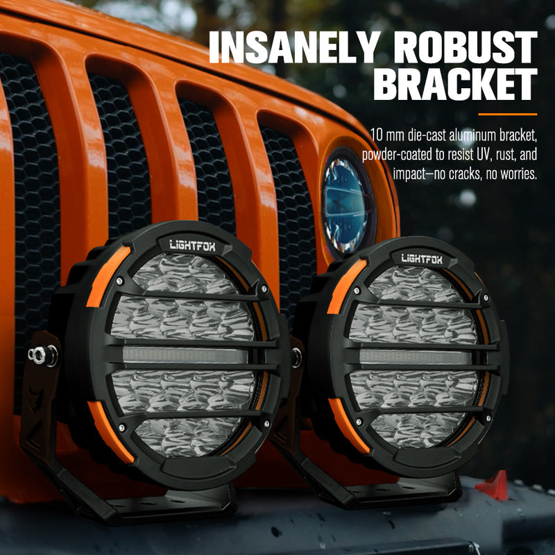 Two Lightfox off-road lights with an orange vehicle grille in the background.