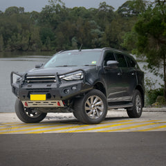 Black Isuzu SUV with a front bumper bull baron a road with trees in the background