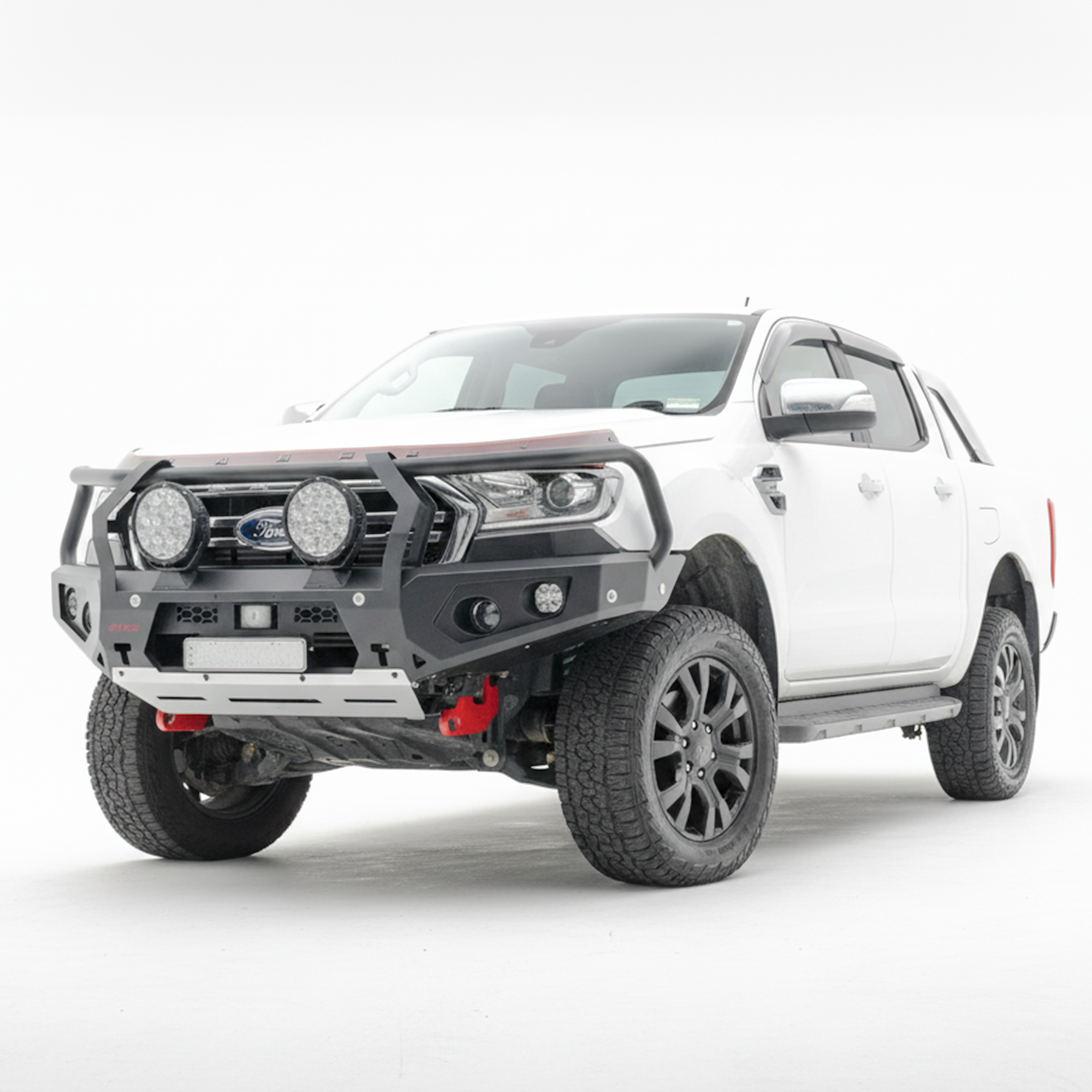 A white Ford Ranger pickup truck bakkie with a heavy-duty black front bumper bull bar, dual round light bars, roof-mounted LED light bar, and off-road tires, photographed on a seamless white studio background.