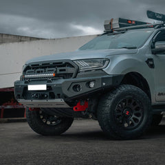 Gray Ford Ranger SUV with Rockarmor bumper and other off-road modifications on a cloudy day
