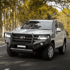Gray Toyota SUV with black Rockarmor bull bar on a road with trees in the background