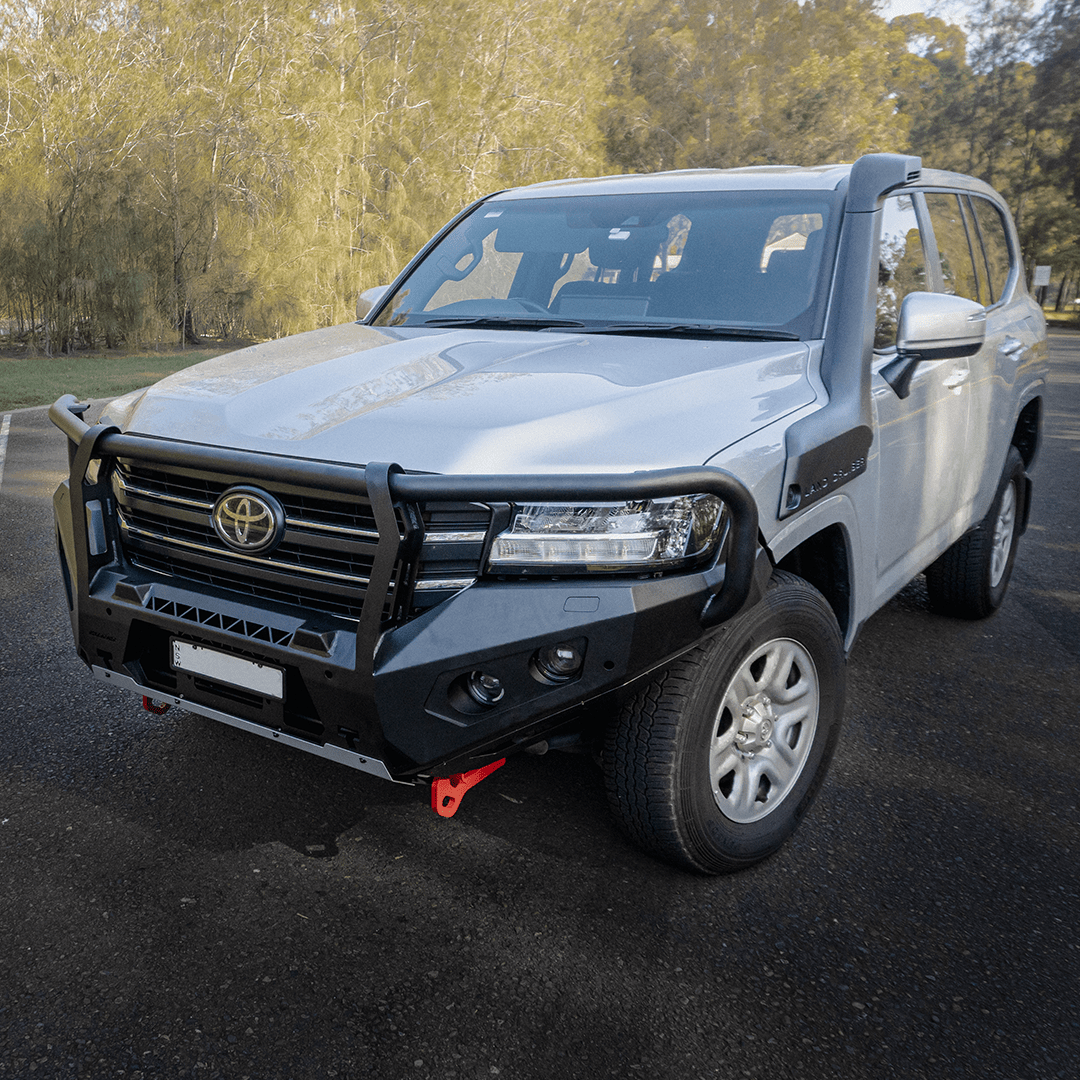 Gray Toyota SUV with a front bumper guard on a road with trees in the background