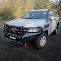 Gray Toyota SUV with a front bumper guard on a road with trees in the background