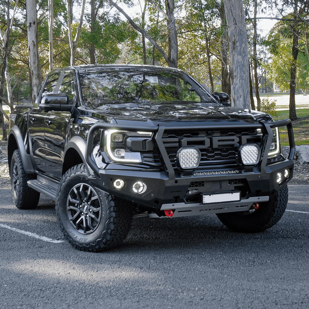 Gray Ford Ranger Raptor bakkie pickup truck with Rockarmor front bumper bull bar parked outside on a tar surface