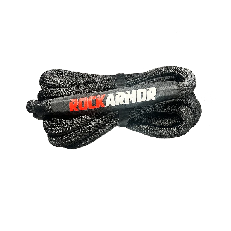 A coiled black braided kinetic recovery rope secured with a black strap, featuring the brand name 'ROCKARMOR' printed in red and white on the center, set against a plain white background.