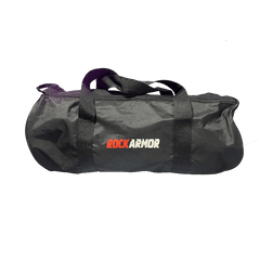 A black cylindrical duffel bag with black handles, featuring the 'ROCKARMOR' logo printed on the front in red, white, and black. The bag is photographed against a solid white background.