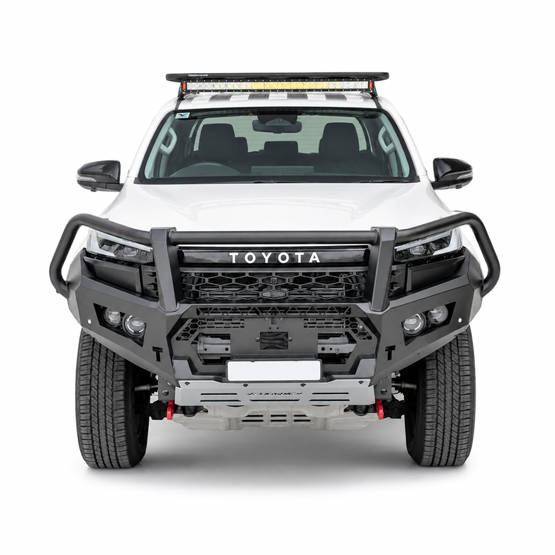 A white Toyota Hilux pickup truck bakkie shown from the front on a clean white studio background, fitted with a heavy-duty black Rockarmor front bumper guard bullbar and a roof-mounted light bar.