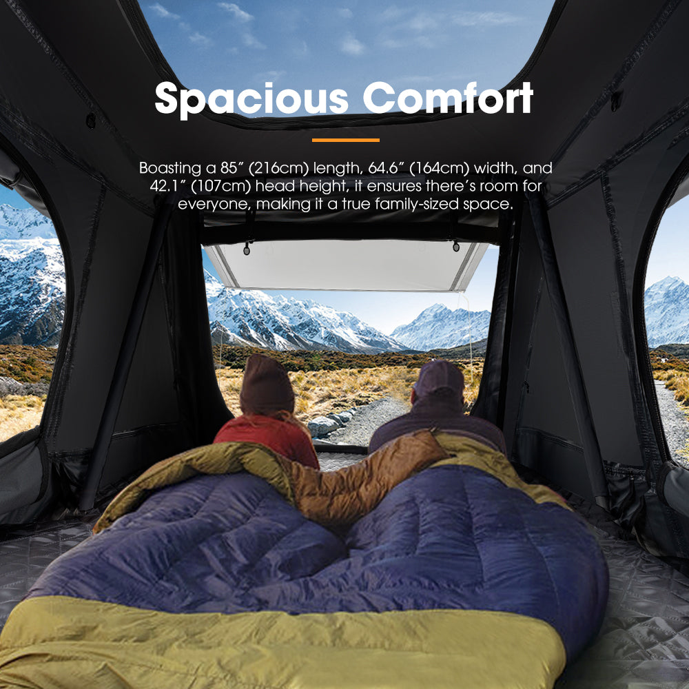 People lying on a bed inside a roof top tent  annex camping shade with mountains in the background, emphasising spacious comfort.