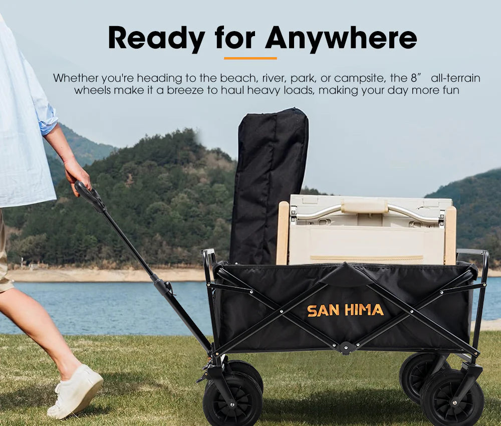 Black folding wagon with 'SAN HIMA' branding being pulled by a person on grass with a scenic background.