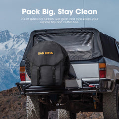 Black wheel, storage, and rubbish bag on a vehicle with mountains in the background and 'San Him' branding.